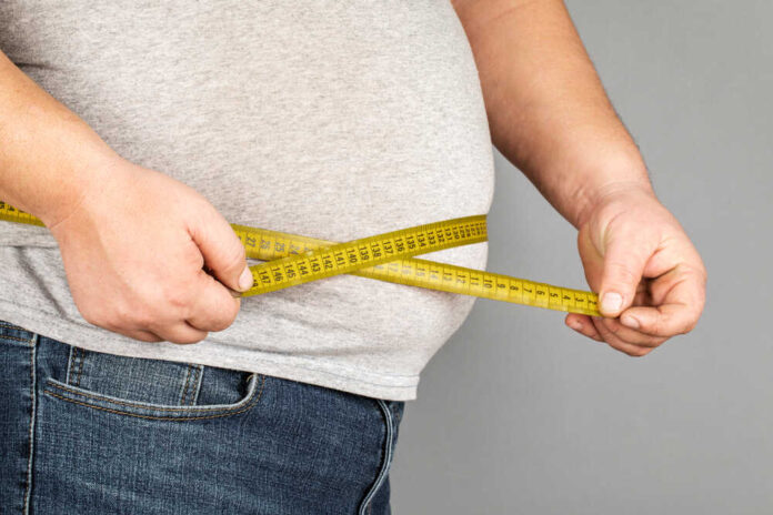 A,Man,Measures,His,Fat,Belly,With,A,Measuring,Tape.