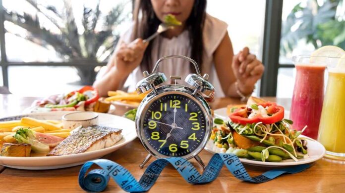 Selective,Focus,Of,Alarm,Clock,With,Woman,Eating,A,Healthy