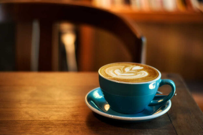 Coffee,In,Blue,Cup,On,Wooden,Table,In,Cafe,With