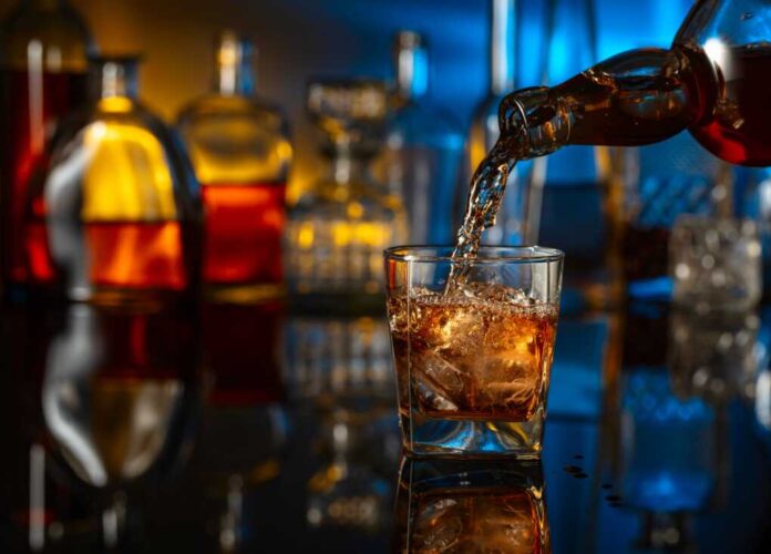 Whiskey,Is,Poured,From,A,Bottle,Into,A,Glass,With