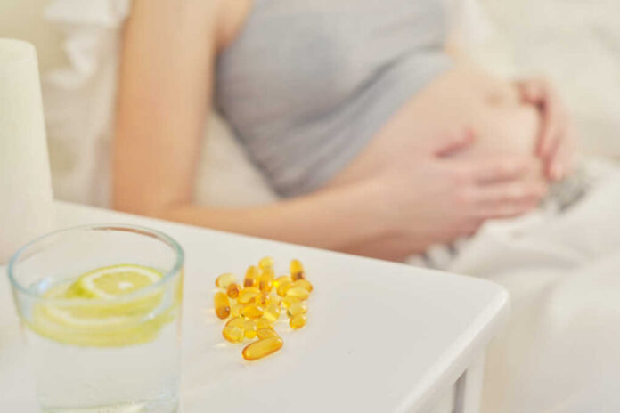 Young,Pregnant,Woman,Taking,Vitamins.,A,,D,,E,,Omega-3,Capsules.