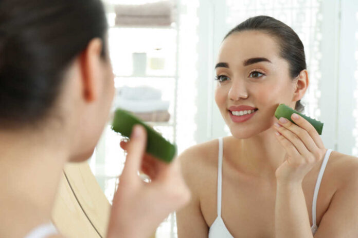 Young,Woman,With,Aloe,Vera,Leaf,Near,Mirror,Indoors
