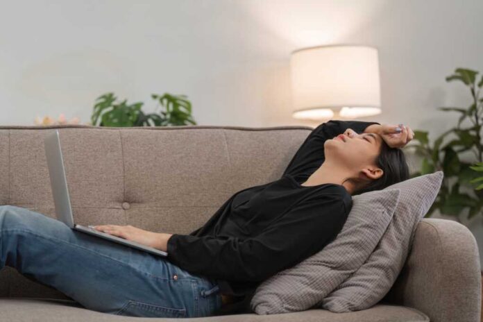 Young,Woman,Feeling,Stressed,And,Overwhelmed,At,Work,,Lying,On