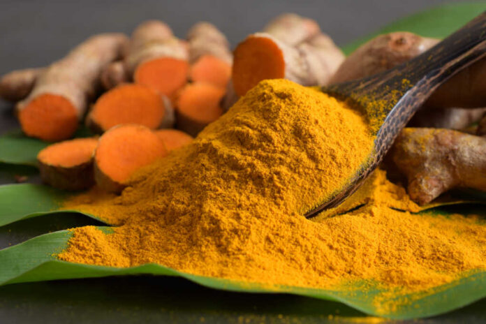 Turmeric,Powder,And,Fresh,Turmeric,(curcumin),On,Black,Background.