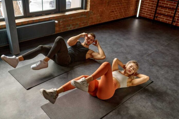 Man,And,Woman,Doing,Abs,Exercise,At,Group,Training,Class