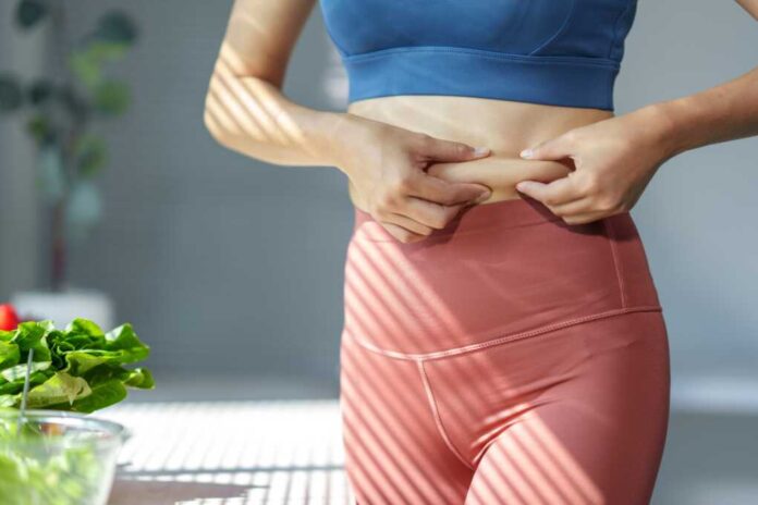 Close-up,Of,A,Woman,In,Sportswear,Pinching,Her,Belly,Fat,