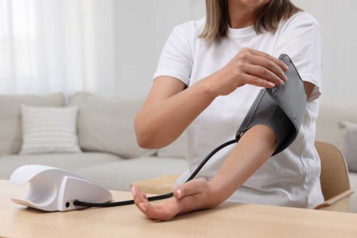 Woman,Measuring,Blood,Pressure,At,Wooden,Table,In,Room,,Closeup