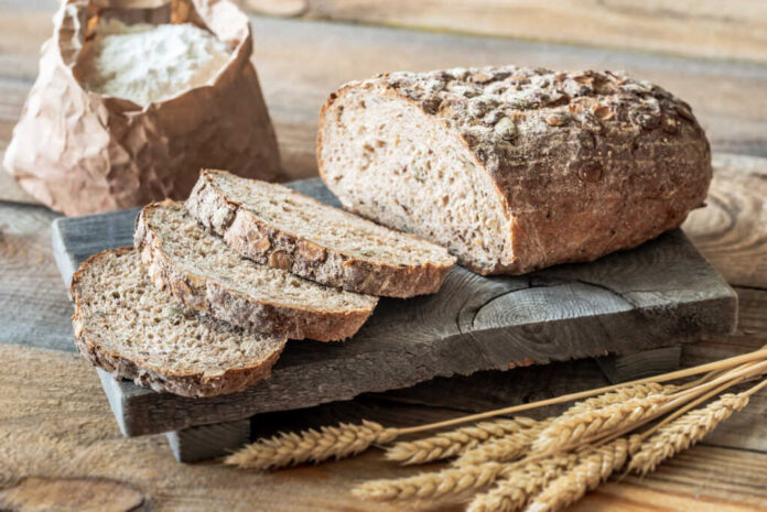 Wholegrain,Bread,With,Ears,Of,Wheat,On,The,Wooden,Board