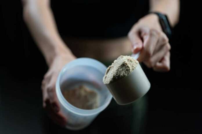 Close,Up,Of,Women,With,Measuring,Scoop,Of,Whey,Protein