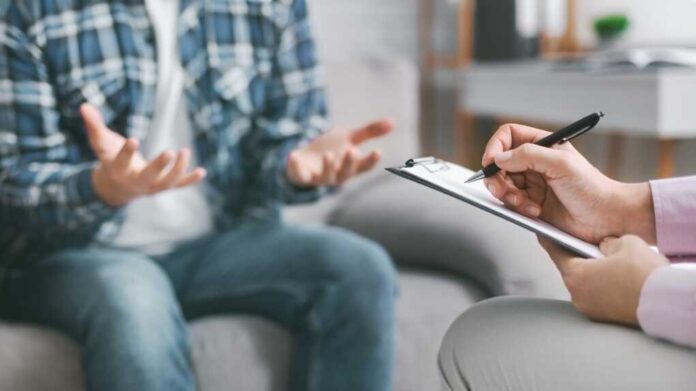 A,Therapist,Is,Seated,Across,From,Their,Patient,And,Taking