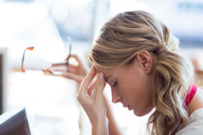 Tensed,Waitress,Sitting,With,Hand,On,Forehead,In,Cafe