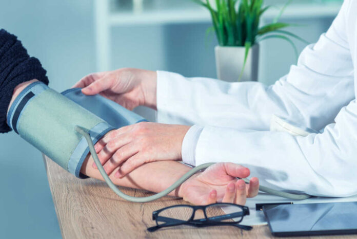 Doctor,Cardiologist,Measuring,Blood,Pressure,Of,Female,Patient,In,Hospital