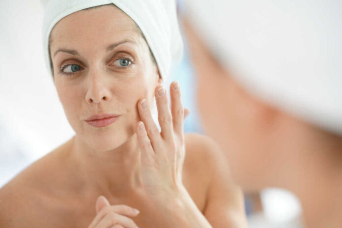 Portrait,Of,Woman,In,Bathroom,Applying,Moisturizing,Cream